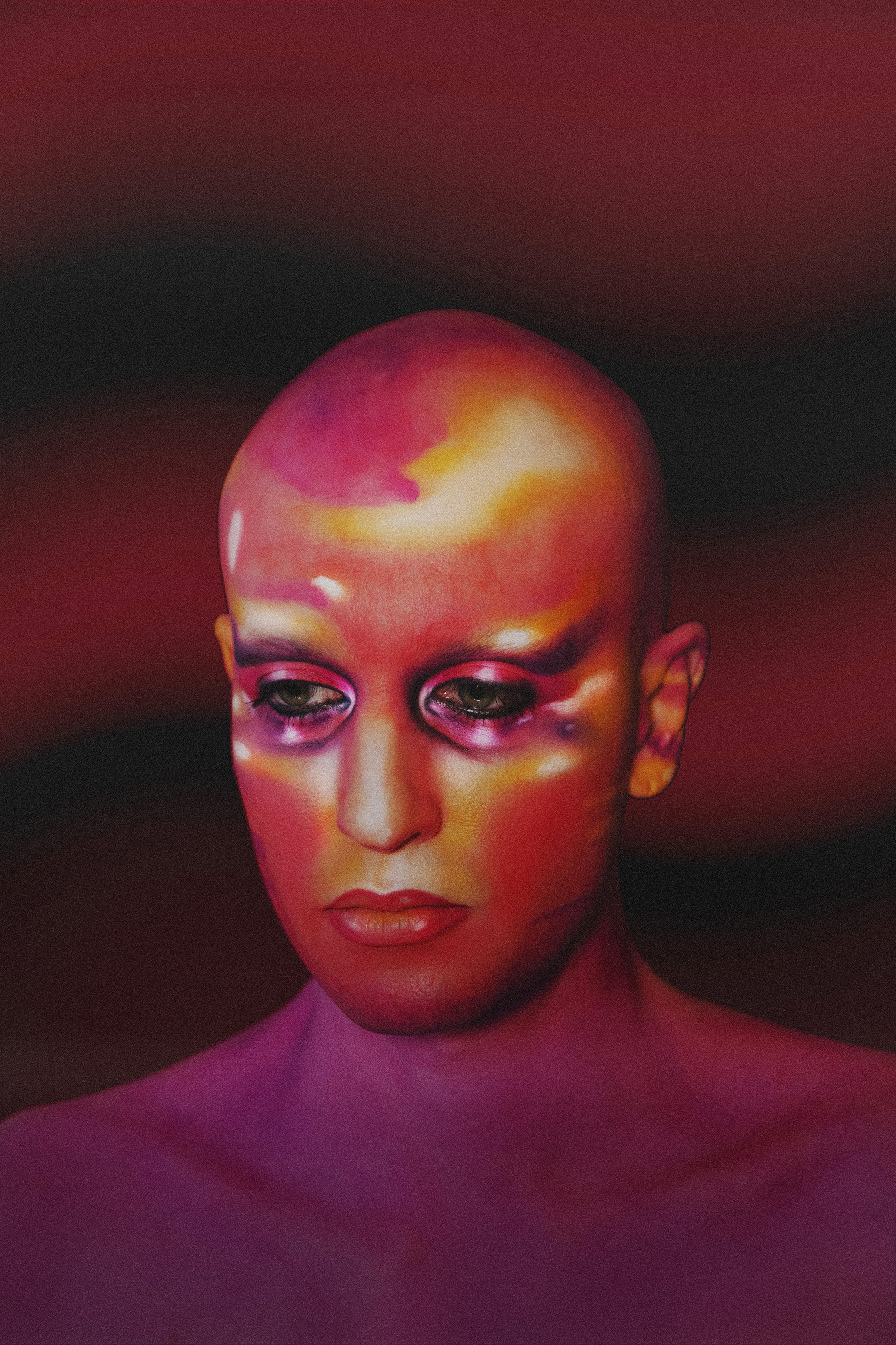 Close up 3/4 portrait of Jesse with sunset colored expressive makeup and eyes open against a dark maroon background